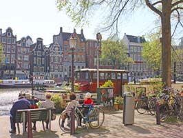 Par på bänkar vid kanal i Amsterdam