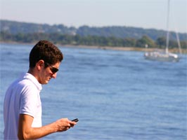 Man ringer med mobiltelefon vid havet
