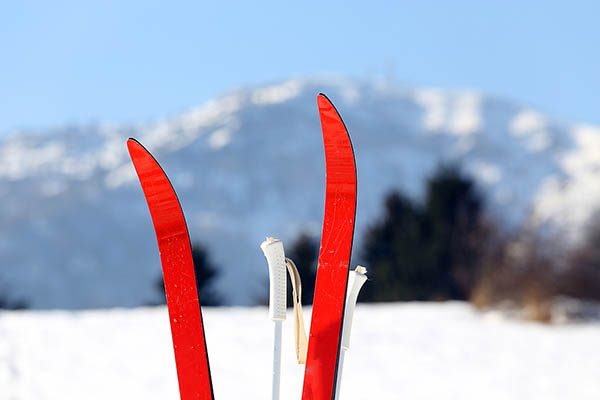 Röda skidor med fjäll i bakgrunden.